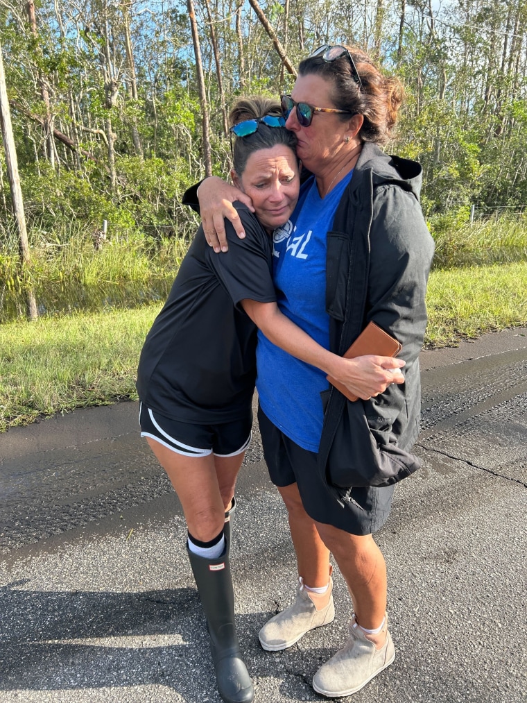 Leslie High, left, and her friend Laurie Lilliott embrace after seeing the devastation to their community of Dekle Beach, Fla., after Hurricane Helene.