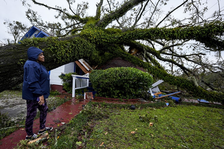 Ronda Bell tends to the landing of an oak tree on her 100-year-old home after Hurricane Helene passed through on Friday, September 27, 2024, in Valdosta, Georgia.