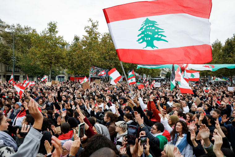 A crowd of protestors hold Lebanon flags