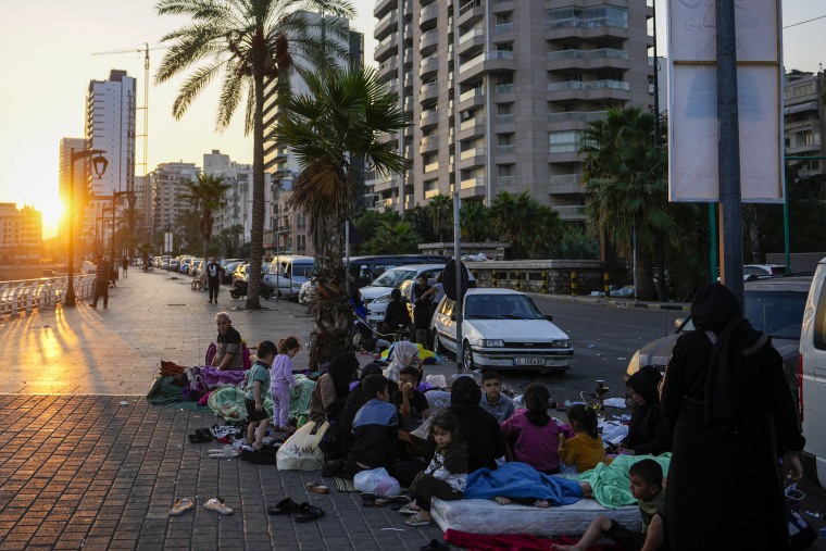 Famílias dormem na rua em Beirute depois de fugirem dos ataques aéreos israelenses. 