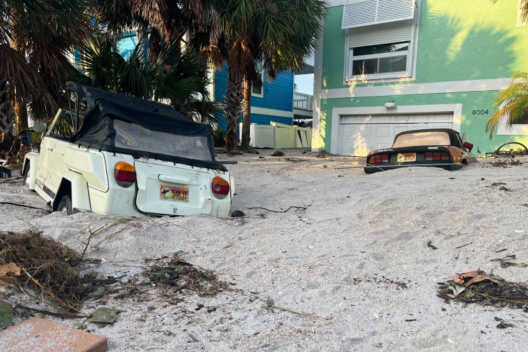 Cars are seen buried in sand after Hurricane Helene made landfall in Treasure Island, Florida.