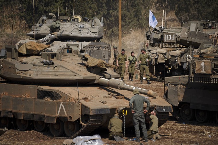 Israeli soldiers work on tanks and armored personnel carriers in northern Israel, Monday, Sept. 30, 2024. 