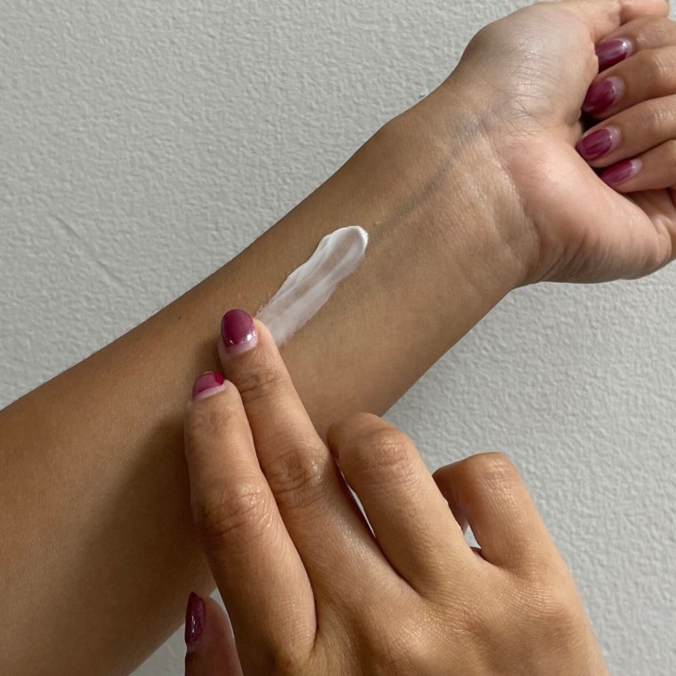 A swatch of the Avène Hydrance Rich Hydrating Cream is on a woman’s arm.