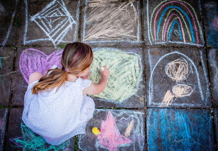 Girl Drawing in Chalk on the Floor Outside in Summer