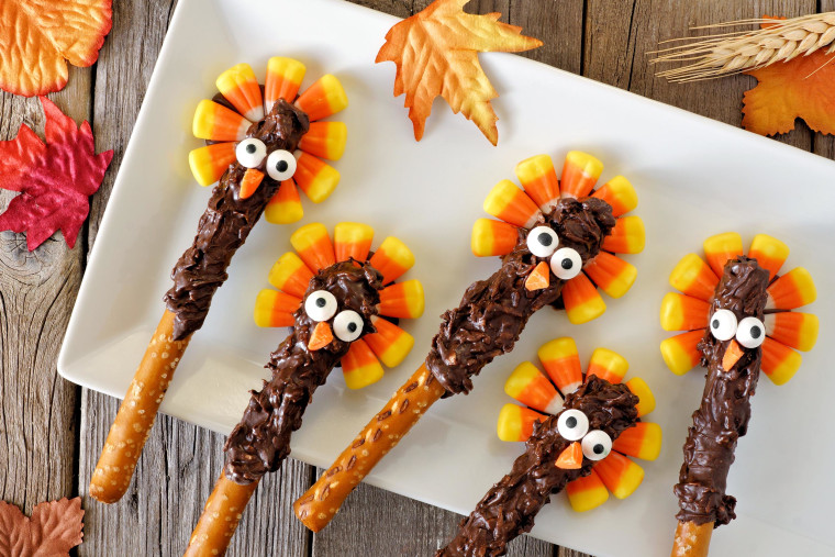 Candy corn turkey pretzel rods on a white plate