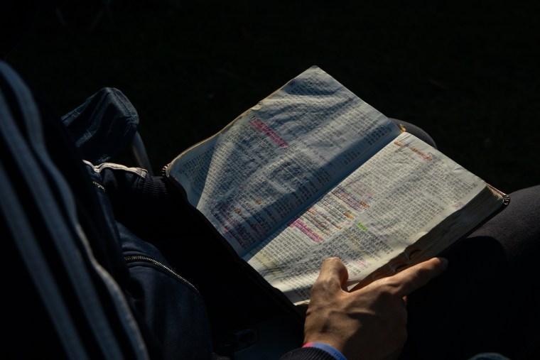 Min Gyu Kim, a Korean pastor, prays with his Bible open during the “A Million Women” rally on Saturday.