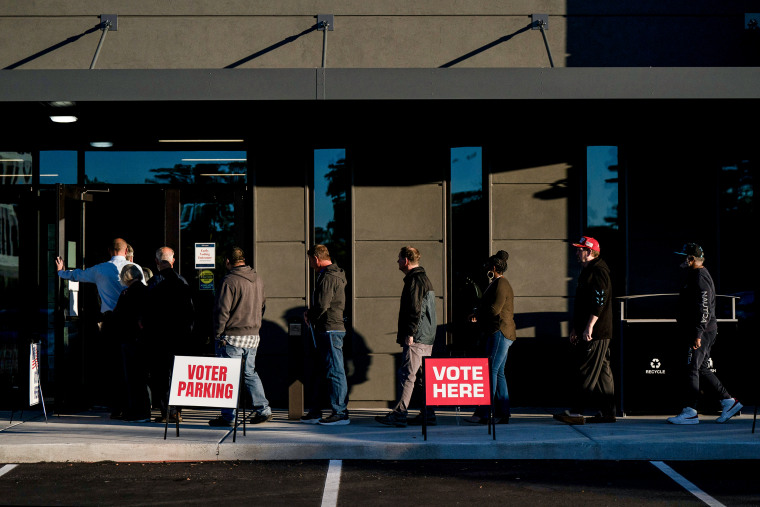 Os eleitores esperam na fila para votar no primeiro dia de votação antecipada em uma seção eleitoral em Wilmington, NC, em 17 de outubro de 2024. 