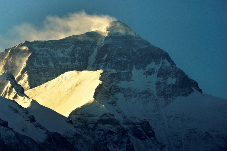 Wind blows snow from the summit at sunrise of the world's highest mountain Mount Everest, also known as Qomolangma, in the Tibet Autonomous Region