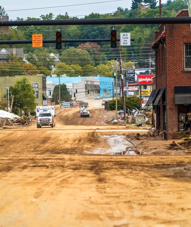 一輛救護車在建築物間的土路上行駛