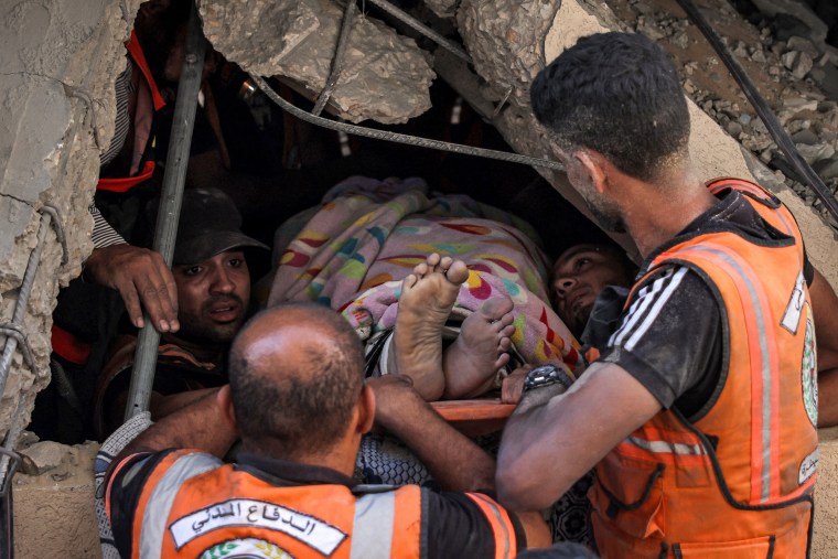 Palestinian Civil Defence rescuers try to extract a victim from a hole underneath the rubble of a collapsed building in Khan Yunis in the southern Gaza Strip on Oct. 2, 2024.