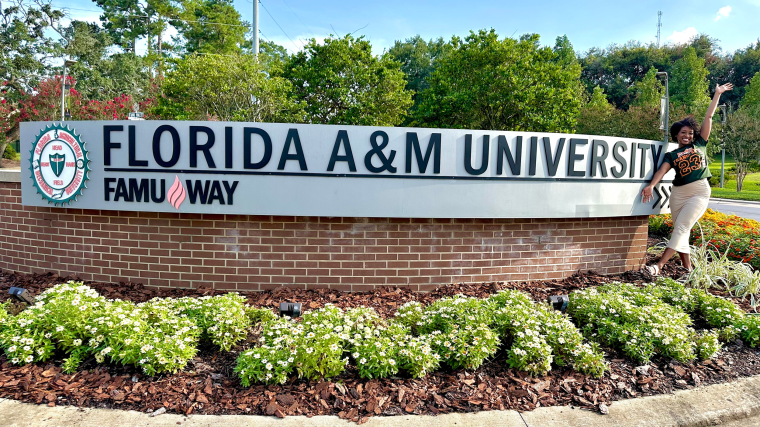 Charisse Lane berpose untuk foto di depan papan nama Florida A&M University