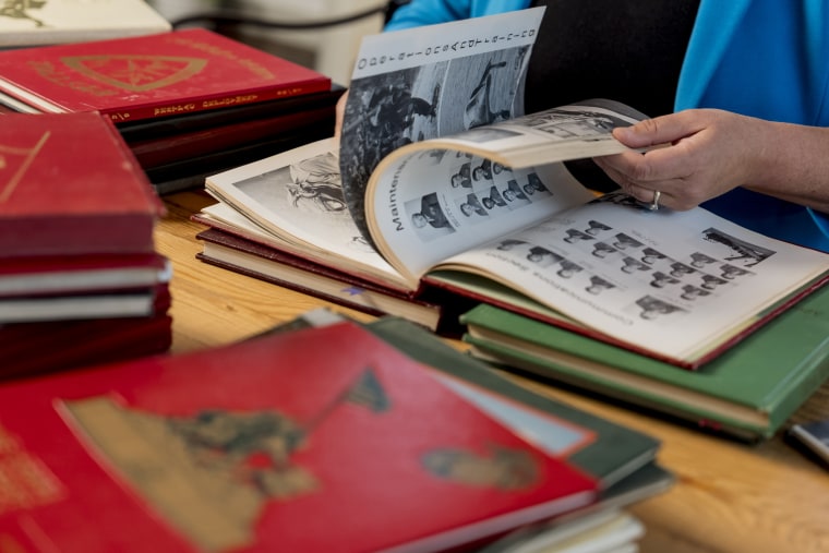 Jessie Hoerman looks through Marine Corps cruise and graduation books at her home in Clayton, Mo.