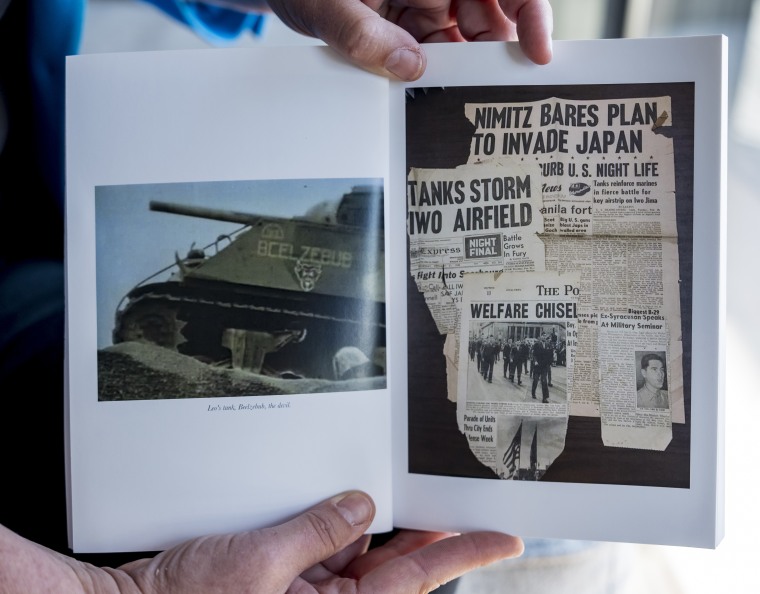 Jessie Hoerman holds a book containing photos and stories about her grandfather, Leo Case.