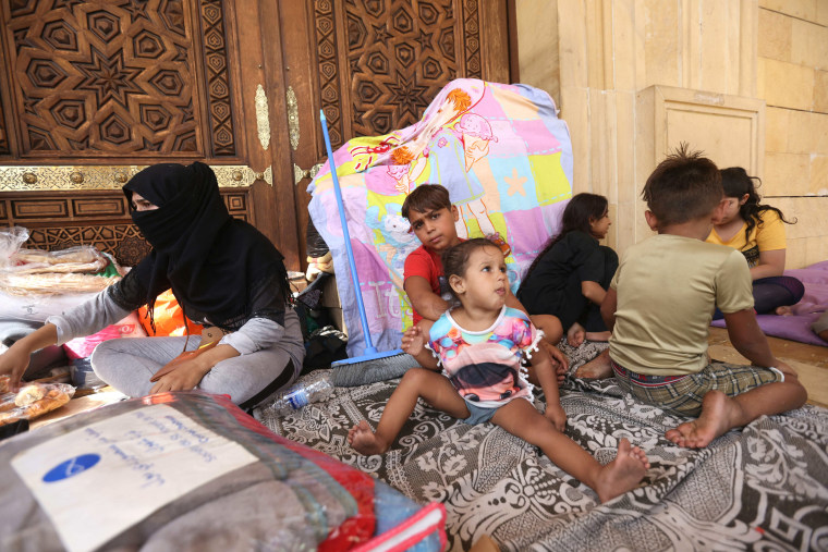 Displaced families take shelter outside the Mohammed al-Amin mosque in downtown Beirut on Oct. 2, 2024. 