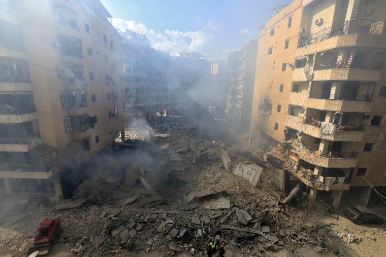 escuers check the destruction at the site of an overnight Israeli airstrike in Beirut's southern suburb of Shayyah on Oct. 2, 2024. 