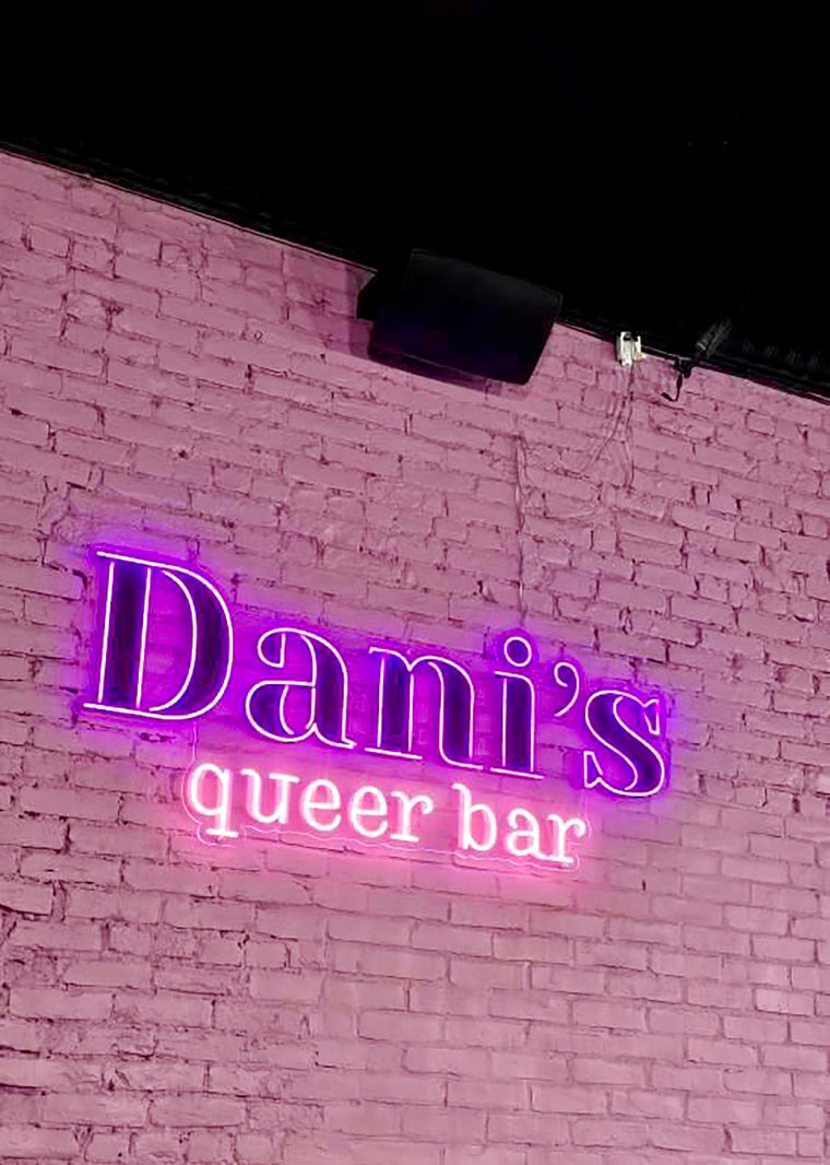 A neon sign adorns an exposed brick wall at Dani's Queer Bar in Boston. 