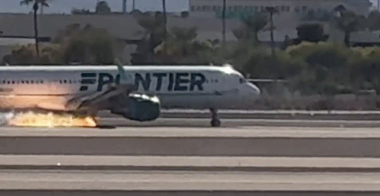 A Frontier flight with flames visible beneath the plane at Harry Reid International Airport in Las Vegas.