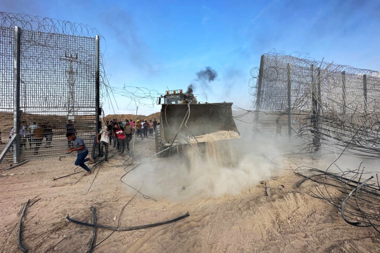 Palestinos cruzando a cerca da fronteira com Israel a partir de Khan Yunis, no sul da Faixa de Gaza Palestinos cruzando a fronteira