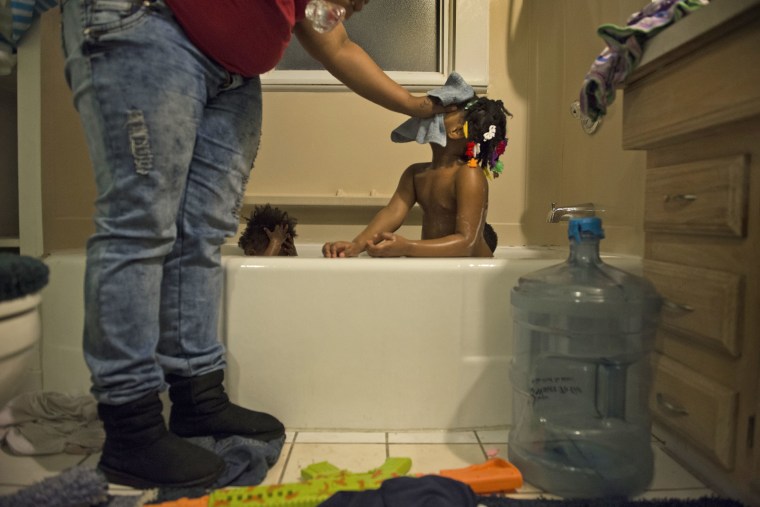 Nakeyja Cade bathes her three children in boiled bottled water in Flint, Mich.