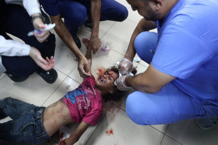 Palestinian medics treat a girl who was injured in Israeli strikes 