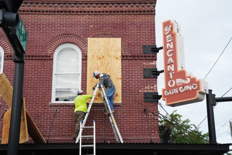 Contractors put plywood over windows in Tampa, Fla., on Oct. 8, 2024.