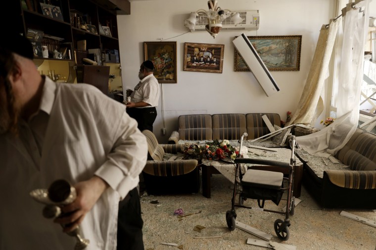 Residents inspect damage on a residential building hit by a rocket on Oct. 8, 2024 in Kiryat Yam near Haifa, Israel. 