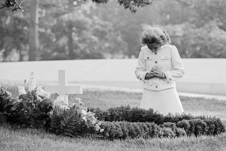 Ethel Kennedy kneels at the grave of husband Robert F. Kennedy