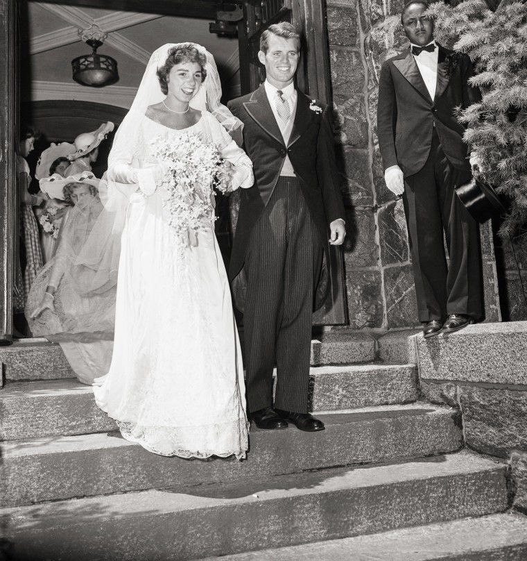 Robert F. Kennedy and his wife leave the church and walk down the stairs in their wedding dress and wedding suit