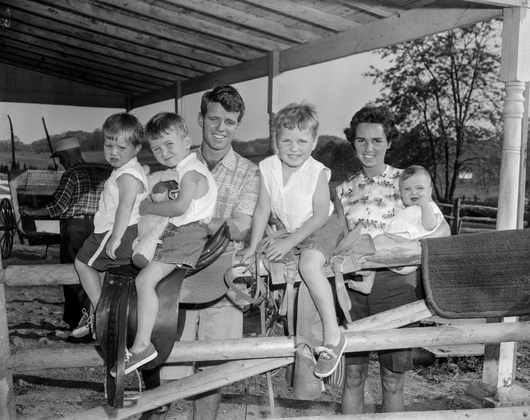 Robert Kennedy and his wife stand outside with four of their children. The children from left are: David Anthony, Robert Francis, Joseph Pat and Mary Courtney.