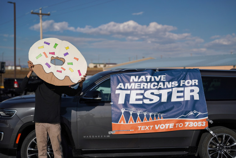 A volunteer hold a donut sign at a get out the vote event for Senator Jon Tester