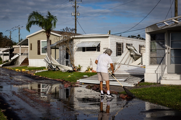 SARASOTA, FL - 10 DE OCTUBRE: Un residente limpia el frente de su m