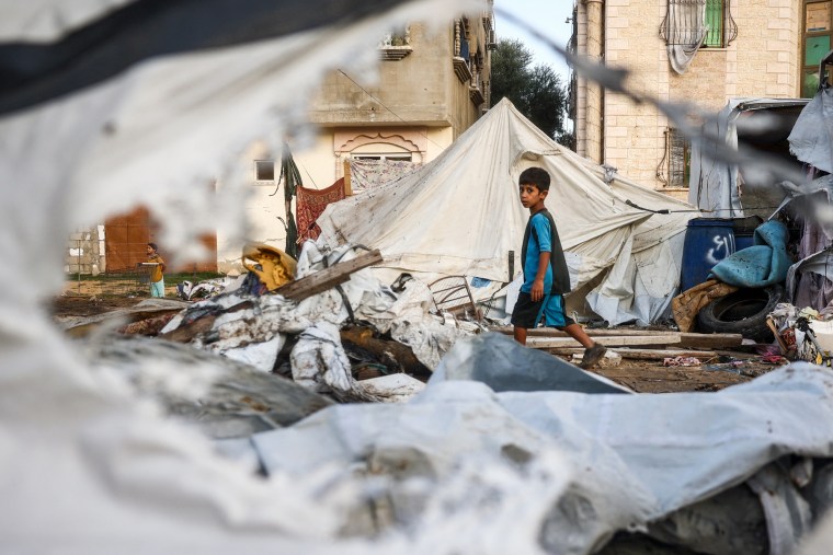 A child walks next to destoyed tents