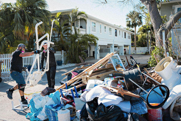 Ricky Brunette and Alex Bull remove a bathroom that was recently damaged in Hurricane Helene in Indian Rocks Beach, Fla., on Oct. 18, 2024.