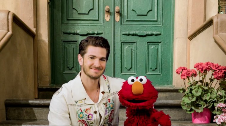 Andrew Garfield e Elmo estão sentados em uma varanda