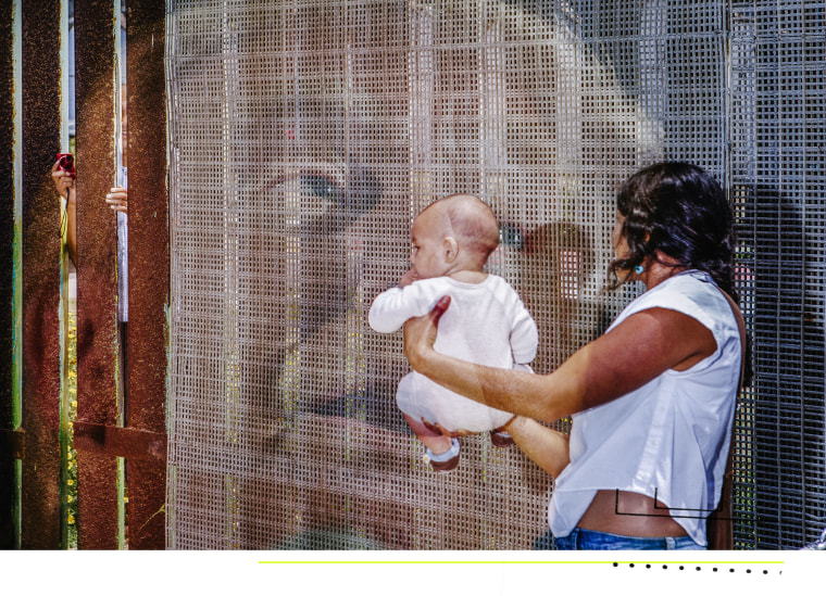 Double exposure: A woman holds her baby near the Mexico-US border wall as someone takes a picture through the other side. Donald Trump's face is seen.