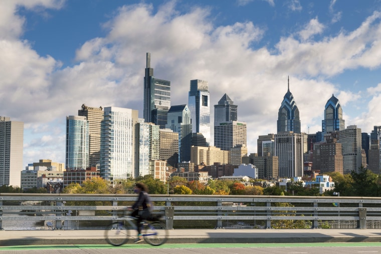 Skyline with cyclist on South Street Bridge at sunset, Philadelphia, Pennsylvania, USA