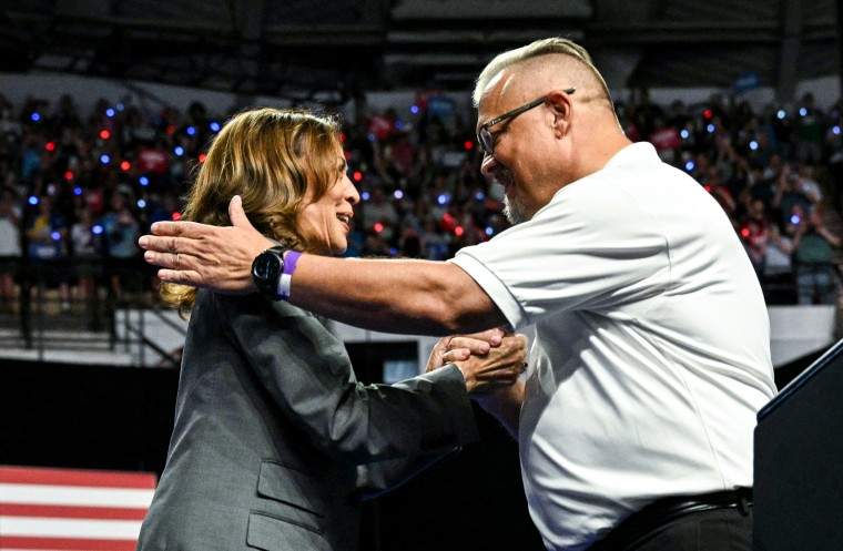 Vice President Kamala Harris is greeted by local team president Bill Carroll