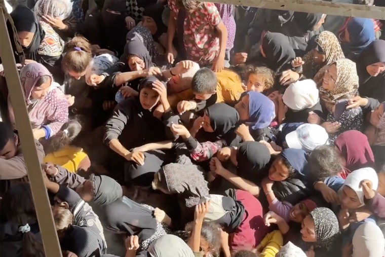 Dois irmãos à espera de pão em Gaza trazem para casa a fome e o desespero que assola o enclave palestiniano.