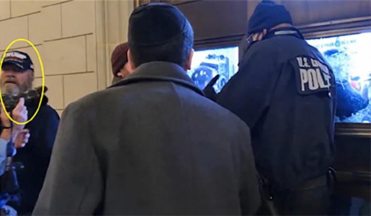 Robert Bixby, circled in yellow, standing by the doors of the Rotunda as a police officer tries to shut them down.