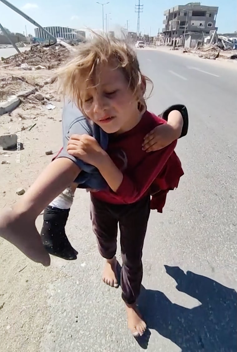 Gaza girl carries her injured sister