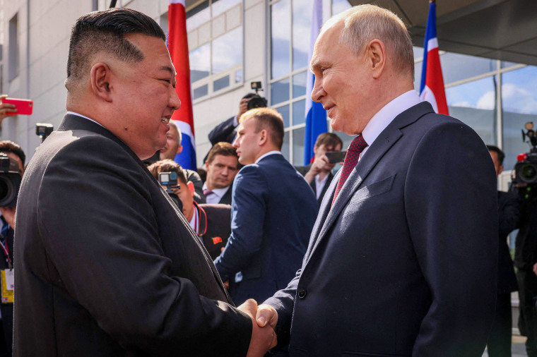 Kim Jong Un shakes hands with Vladimir Putin.