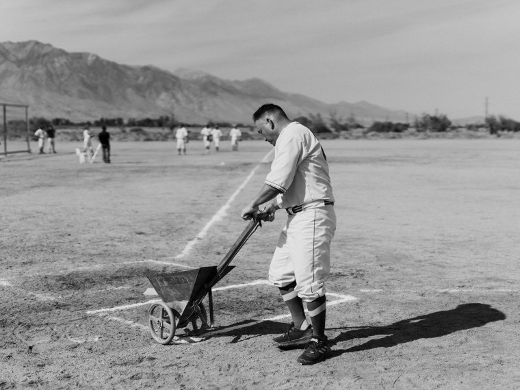 Marty Sakata laying down a fresh layer of chalk on the field with a historical chalk liner.