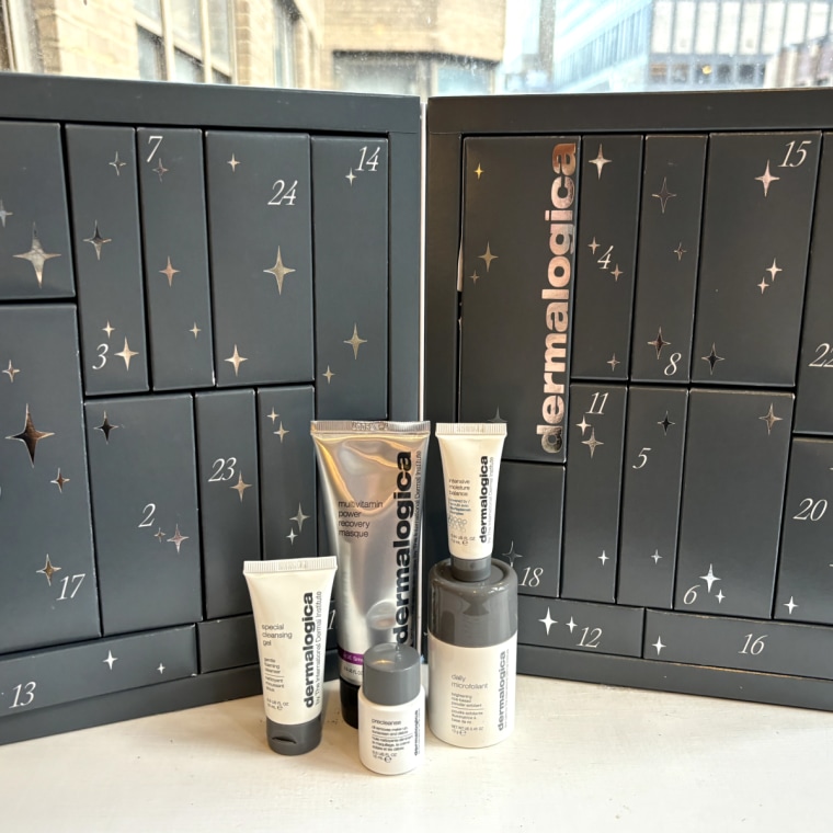 Dermalogica’s Advent calendar in front of a window with some of the brand’s products in front of it.