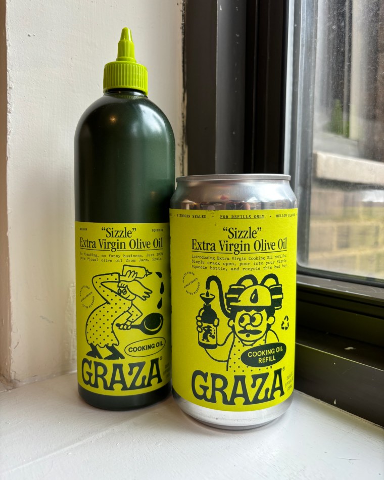 A squeeze bottle (left) and a refill can (right) of Graza’s Sizzle Extra Virgin Olive Oil in front of a window.