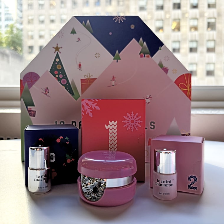 Le Mini Macaron’s Advent calendar standing up on a table with a handful of the brand’s products in front of it.