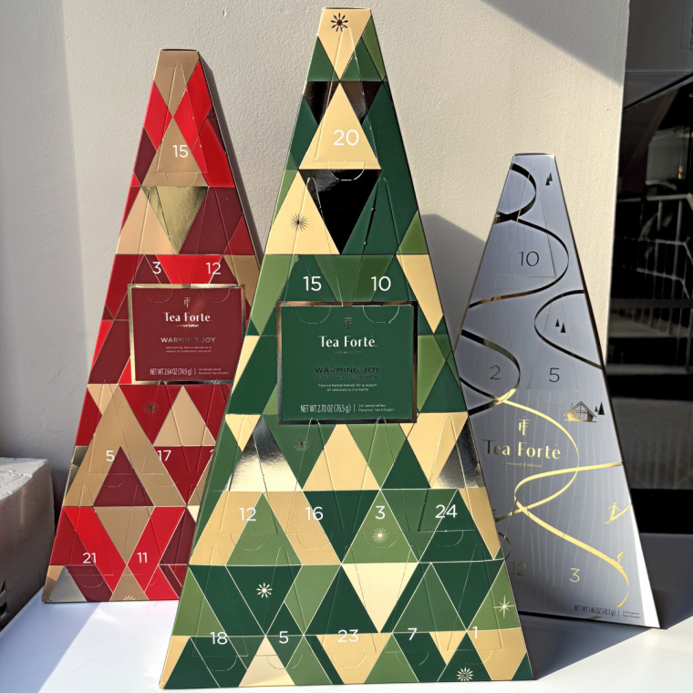 Three triangle-shaped Tea Forte Advent calendars standing up together on a table.