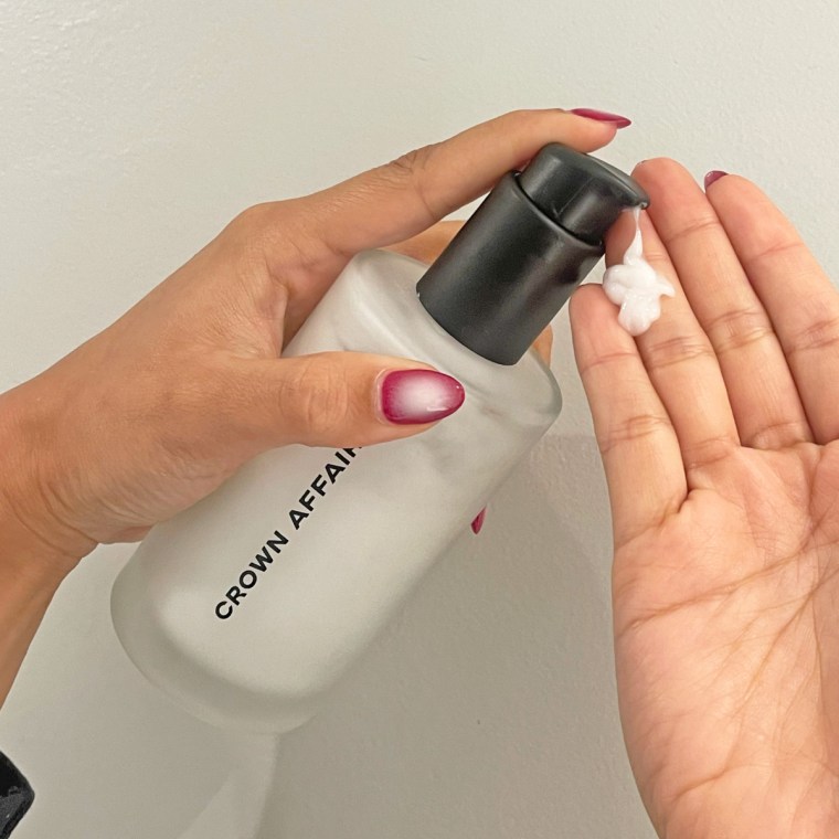 Woman pumps Crown Affair’s The Leave-In Conditioner in her hand.