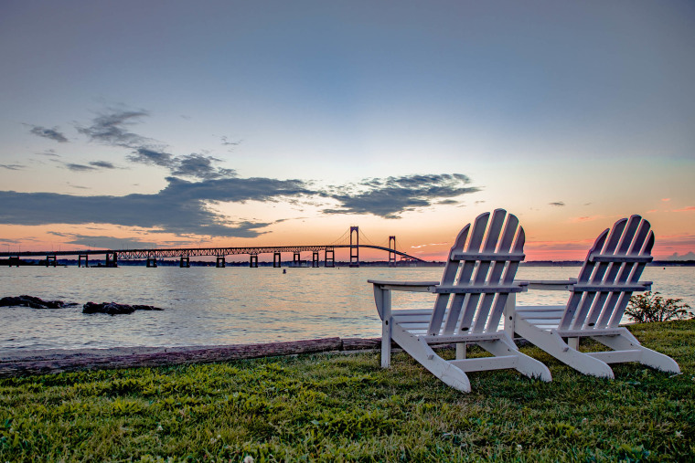Empty chairs on beach against sky during sunset, Newport, Rhode Island.