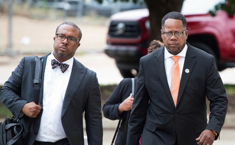 Two men walking in a parking lot, Aaron Banks is on the right