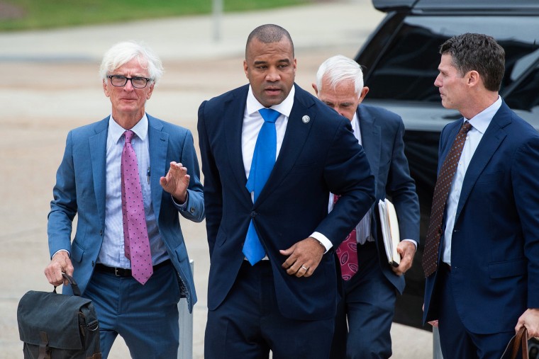 A group of four men walking in a parking lot, Jody Owens is center